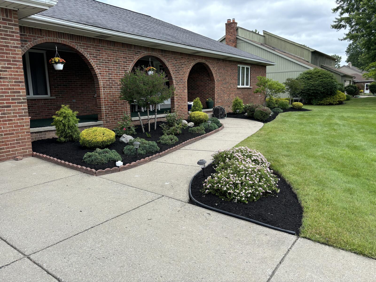 Beautiful landscaped property showcasing lawn care, garden beds, and outdoor design in Williamsville and Amherst NY