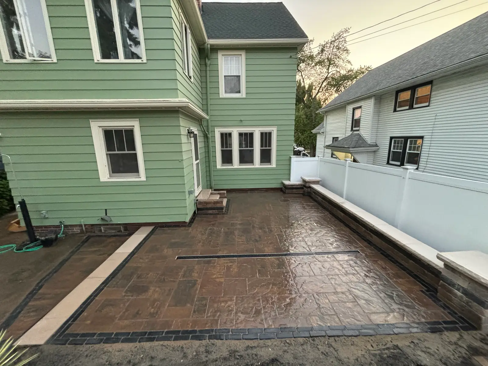 New stamped-concrete patio with decorative border and seat wall